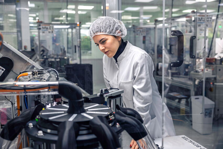 Eine MFORM-Mitarbeiterin verfolgt die Produktion von Produkten in einer Produktionsmaschine